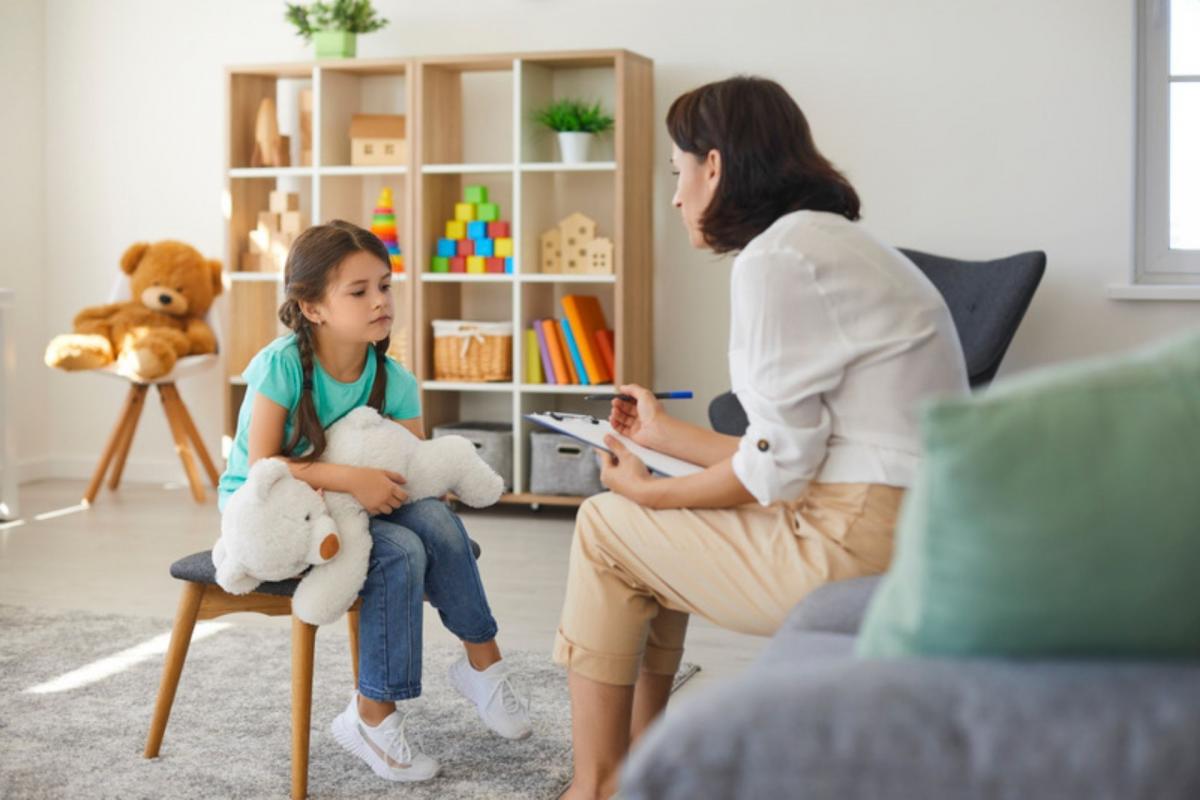 terapeutka rozmawia z dzieckiem w pokoju dziecięcym